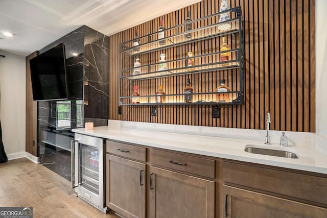 2505 Astaire Ct NW, Atlanta, GA 30318 - bar area featuring wine cooler, a sink, light wood-style floors, and baseboards