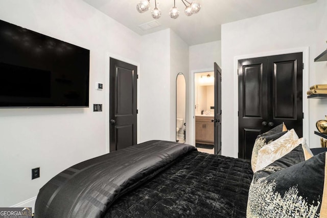 2505 Astaire Ct NW, Atlanta, GA 30318 - bedroom featuring a chandelier, baseboards, and connected bathroom