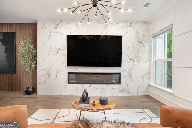 2505 Astaire Ct NW, Atlanta, GA 30318 - detailed view of a premium fireplace, wood finished floors, a chandelier, and an accent wall
