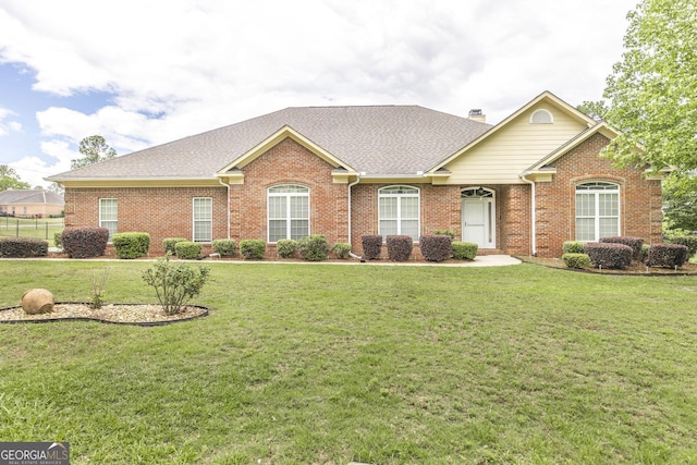 view of front of property with brick siding, a front yard, and a shingled roof