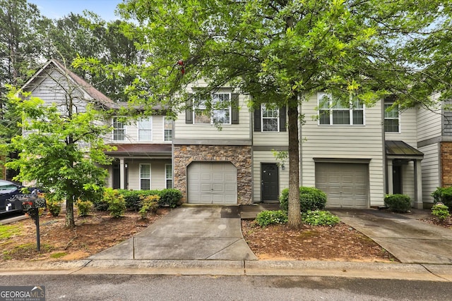 547 SE Tufton Trl SE, Atlanta, GA 30354 - townhome / multi-family property featuring driveway, an attached garage, and stone siding