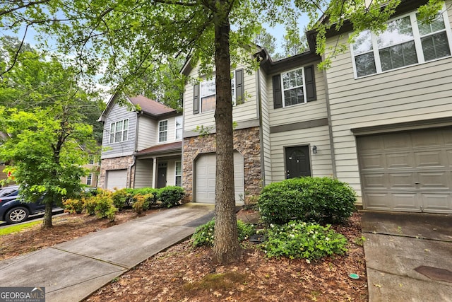 547 SE Tufton Trl SE, Atlanta, GA 30354 - view of front facade with stone siding, concrete driveway, and a garage