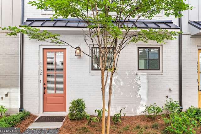4462 Dandelion Ln, Atlanta, GA 30342 - entrance to property featuring brick siding, a standing seam roof, metal roof, and board and batten siding