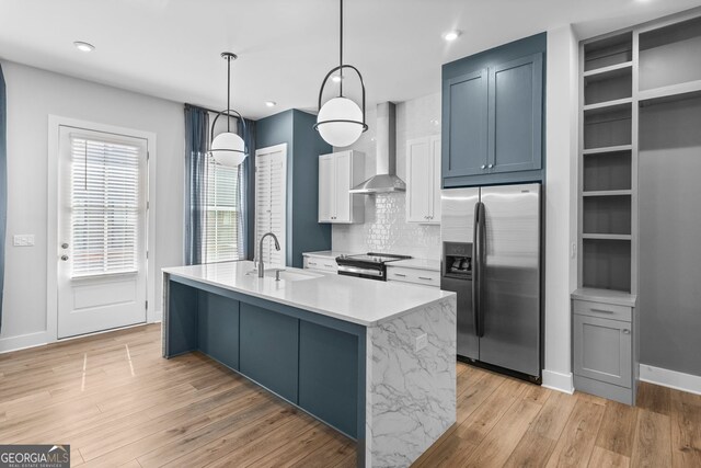 4462 Dandelion Ln, Atlanta, GA 30342 - kitchen featuring stainless steel appliances, a sink, wall chimney range hood, light countertops, and light wood-type flooring