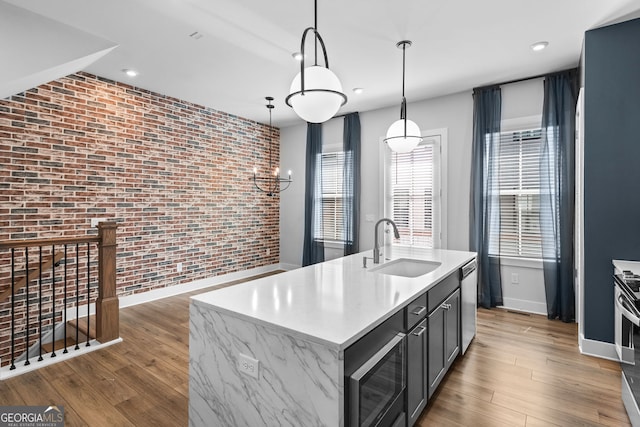 4462 Dandelion Ln, Atlanta, GA 30342 - kitchen featuring stainless steel appliances, a sink, brick wall, healthy amount of natural light, and wood finished floors