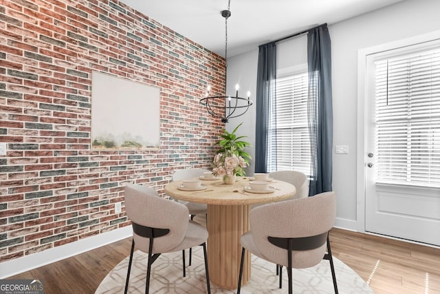 4462 Dandelion Ln, Atlanta, GA 30342 - dining room featuring brick wall, light wood-type flooring, baseboards, and an accent wall