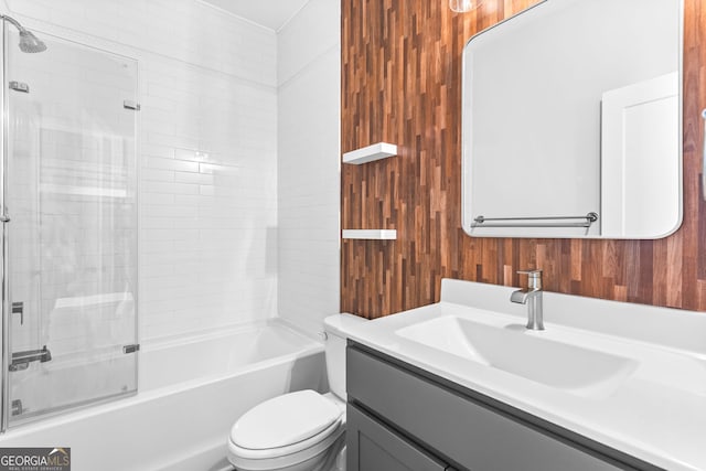 4462 Dandelion Ln, Atlanta, GA 30342 - bathroom with toilet, vanity, wood walls, and bath / shower combo with glass door