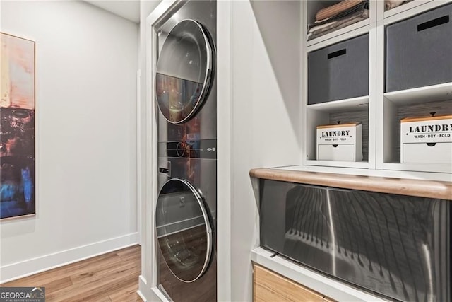 4462 Dandelion Ln, Atlanta, GA 30342 - clothes washing area featuring stacked washer / drying machine, wood finished floors, and baseboards