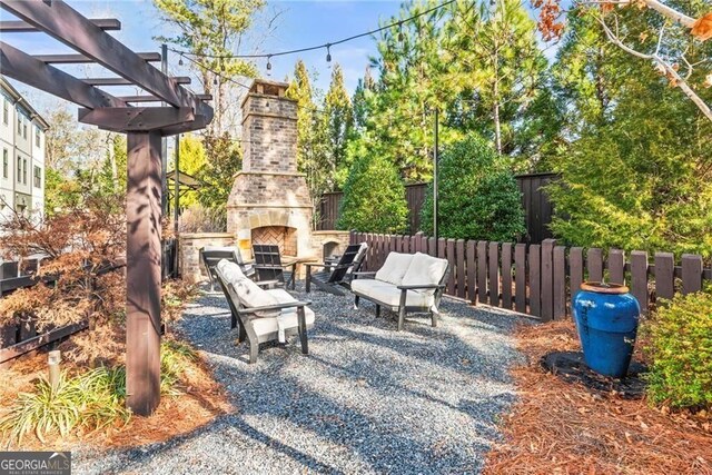 4462 Dandelion Ln, Atlanta, GA 30342 - view of patio featuring an outdoor stone fireplace, fence, and a pergola