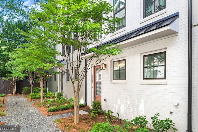 4462 Dandelion Ln, Atlanta, GA 30342 - view of side of property featuring brick siding, fence, a standing seam roof, and metal roof