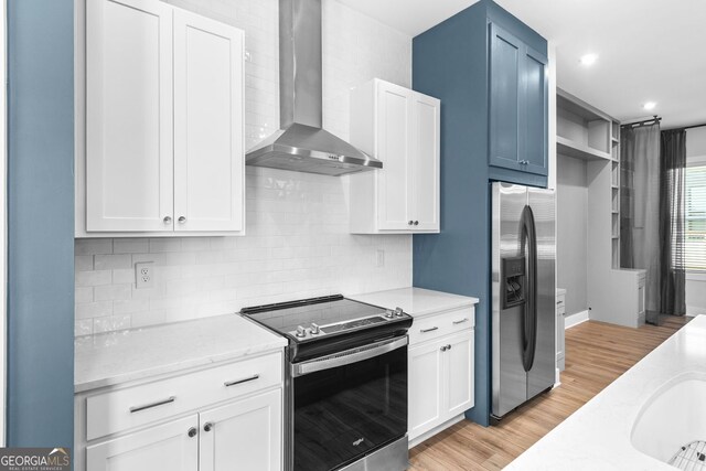 4462 Dandelion Ln, Atlanta, GA 30342 - kitchen with appliances with stainless steel finishes, wall chimney exhaust hood, tasteful backsplash, light stone counters, and white cabinetry