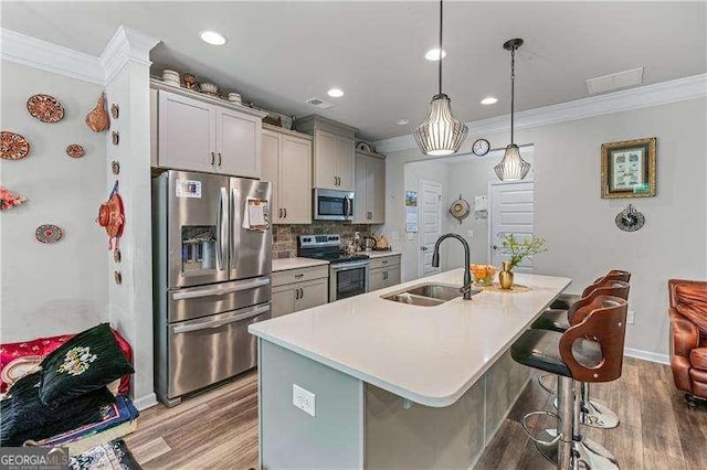 6237 Thorncrest Dr Unit 10, Tucker, GA 30084 - kitchen featuring appliances with stainless steel finishes, ornamental molding, a sink, gray cabinets, and light wood finished floors