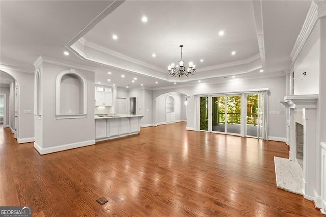 5816 Chamblee Dunwoody, Atlanta, GA 30338 - unfurnished living room featuring arched walkways, a tray ceiling, a chandelier, recessed lighting, and a fireplace