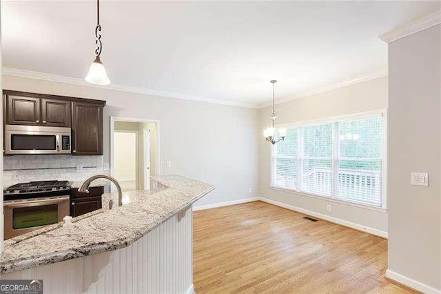 5065 Hickory Hills Dr, Woodstock, GA 30188 - kitchen featuring appliances with stainless steel finishes, dark brown cabinetry, light wood-style flooring, a chandelier, and hanging light fixtures
