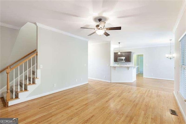 5065 Hickory Hills Dr, Woodstock, GA 30188 - unfurnished living room with ornamental molding, stairs, light wood finished floors, ceiling fan, and baseboards