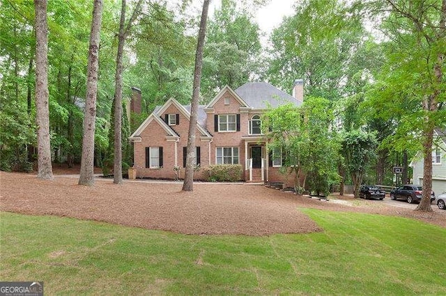 5065 Hickory Hills Dr, Woodstock, GA 30188 - view of front of home featuring a chimney, a front yard, and brick siding