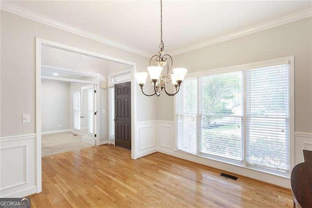 5065 Hickory Hills Dr, Woodstock, GA 30188 - unfurnished dining area featuring a chandelier, light wood-type flooring, ornamental molding, a wainscoted wall, and a decorative wall