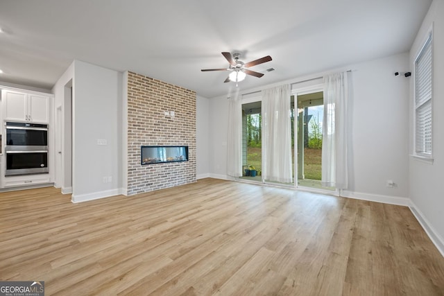 730 Lanarck Way, Peachtree City, GA 30269 - unfurnished living room featuring a ceiling fan, light wood-style floors, and a brick fireplace