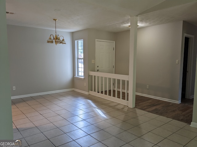 6260 Marbut Farms Ter, Lithonia, GA 30058 - unfurnished room featuring tile patterned floors, baseboards, a chandelier, and a textured ceiling