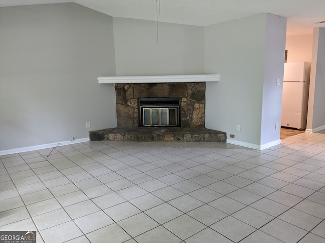 6260 Marbut Farms Ter, Lithonia, GA 30058 - unfurnished living room with tile patterned flooring, a stone fireplace, vaulted ceiling, and baseboards