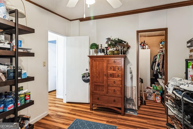 bedroom featuring wood finished floors, ornamental molding, and a ceiling fan