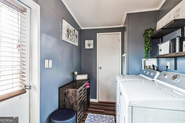 washroom with washing machine and dryer, wood finished floors, and a textured ceiling