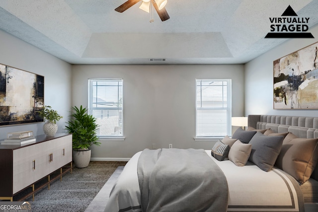 1436 Arbor Place Dr, Morrow, GA 30260 - bedroom with a tray ceiling, multiple windows, baseboards, a textured ceiling, and ceiling fan