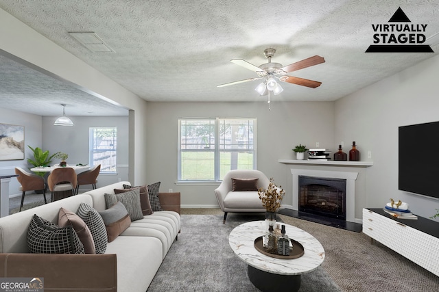 1436 Arbor Place Dr, Morrow, GA 30260 - carpeted living area featuring a fireplace, a textured ceiling, baseboards, and a ceiling fan