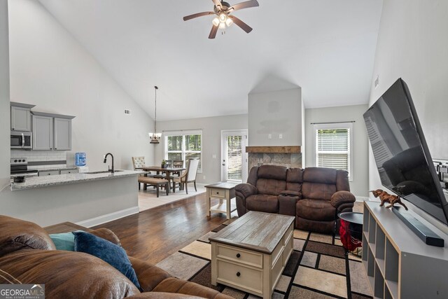 121 Bob Cat Trl, Mansfield, GA 30055 - living area featuring a ceiling fan, plenty of natural light, high vaulted ceiling, light wood-style floors, and a chandelier