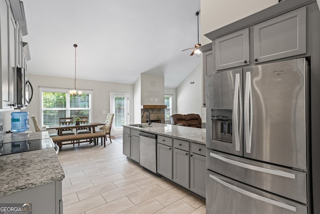 kitchen with stainless steel appliances, gray cabinets, ceiling fan, and lofted ceiling