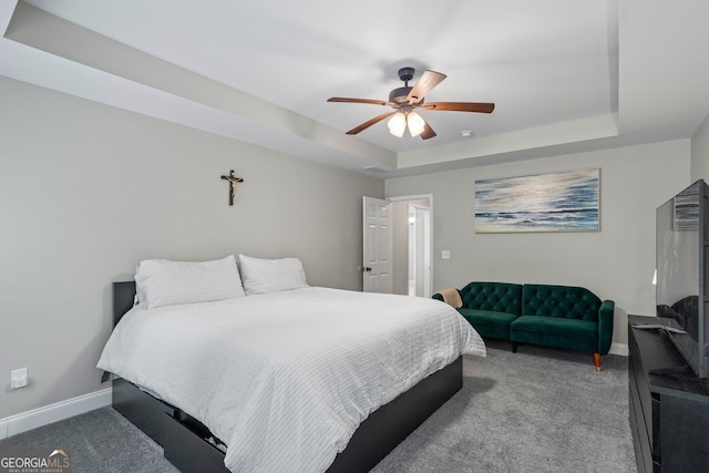 bedroom featuring carpet floors, baseboards, ceiling fan, and a raised ceiling