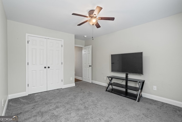 unfurnished bedroom with carpet flooring, a closet, baseboards, and ceiling fan