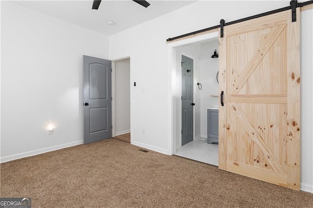 994 Byron Dr SW, Atlanta, GA 30310 - unfurnished bedroom featuring a barn door, carpet, baseboards, ensuite bathroom, and ceiling fan