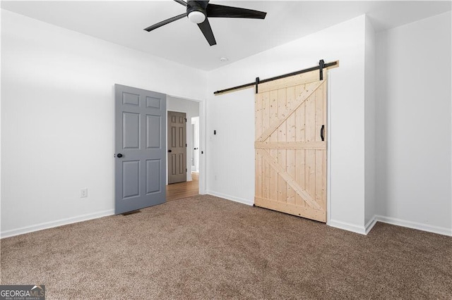 994 Byron Dr SW, Atlanta, GA 30310 - unfurnished bedroom featuring carpet flooring, a barn door, baseboards, and a ceiling fan