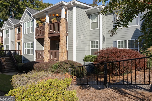 1102 Madison Ln SE, Smyrna, GA 30080 - view of property exterior with a balcony, fence, and stairway