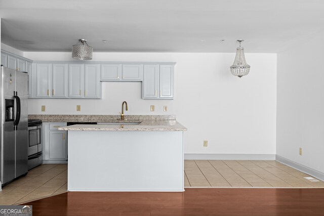 1102 Madison Ln SE, Smyrna, GA 30080 - kitchen featuring appliances with stainless steel finishes, light tile patterned floors, a sink, and light stone counters