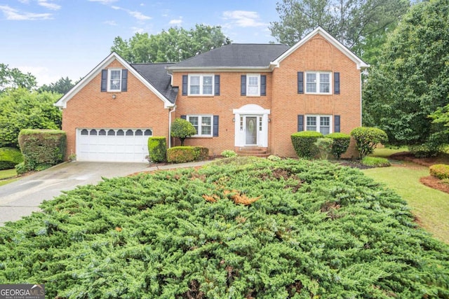 colonial home with brick siding, concrete driveway, and an attached garage