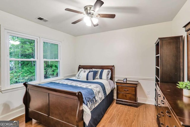 bedroom with light wood-style floors, baseboards, and a ceiling fan
