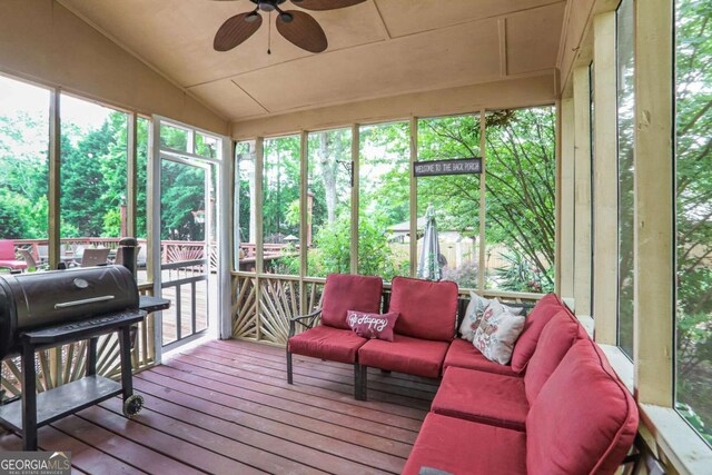 sunroom with ceiling fan, an outdoor hangout area, and lofted ceiling