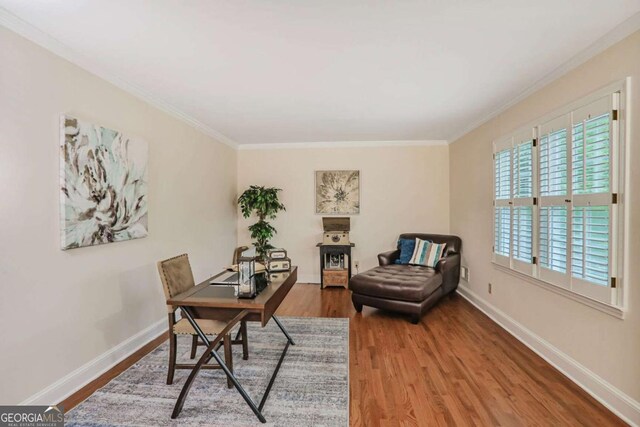 office space featuring wood finished floors, crown molding, and baseboards