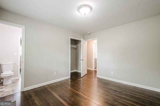 unfurnished bedroom with wood finished floors, baseboards, and a closet