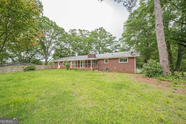 rear view of house with brick siding, central AC, and a chimney