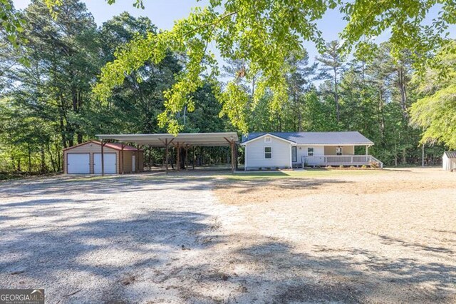 view of front of home featuring an outbuilding, a detached garage, and driveway