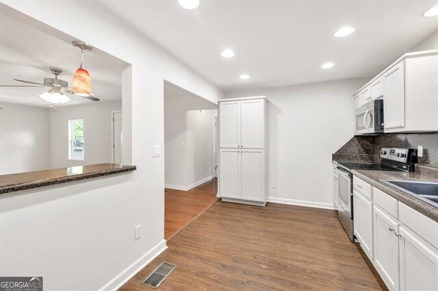 kitchen featuring stainless steel appliances, ceiling fan, recessed lighting, baseboards, and white cabinetry