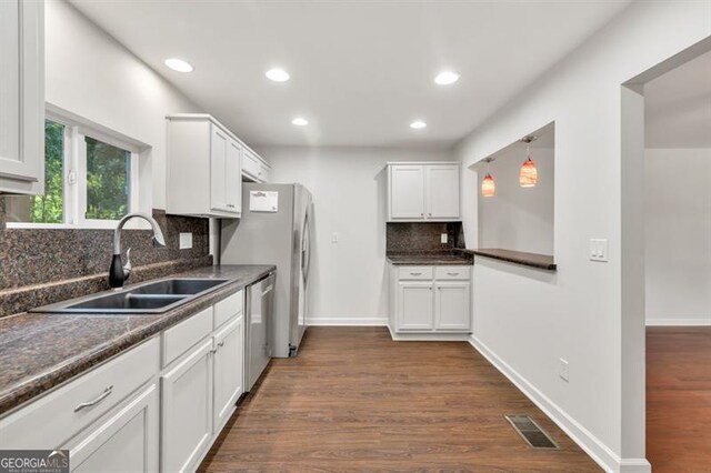 kitchen featuring a sink, stainless steel appliances, backsplash, white cabinets, and recessed lighting