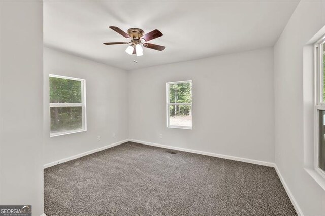 spare room featuring carpet, plenty of natural light, a ceiling fan, and baseboards
