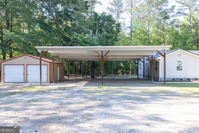 view of car parking with a detached garage and a carport