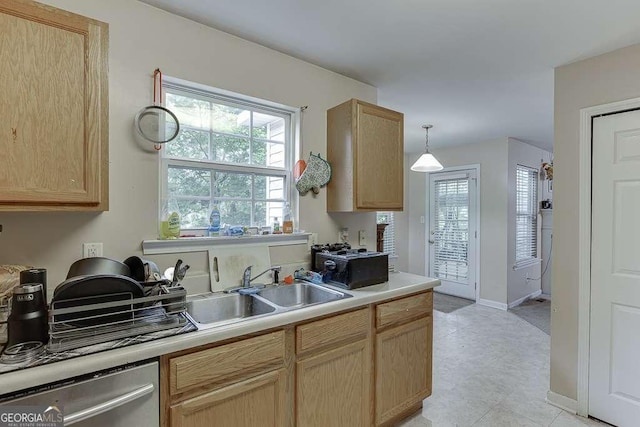 kitchen featuring dishwasher, light brown cabinetry, baseboards, light countertops, and a sink