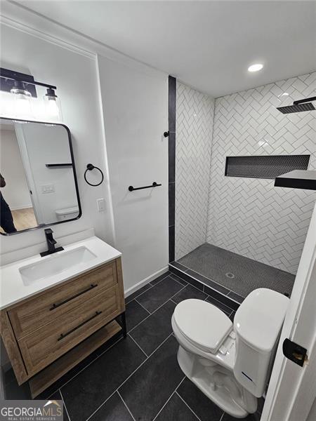 775 Lee Andrews Ave, Atlanta, GA 30315 - bathroom with toilet, a tile shower, vanity, tile patterned floors, and recessed lighting