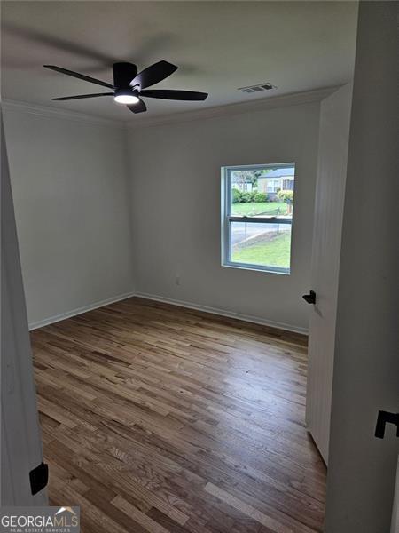 775 Lee Andrews Ave, Atlanta, GA 30315 - spare room featuring crown molding, wood finished floors, a ceiling fan, and baseboards